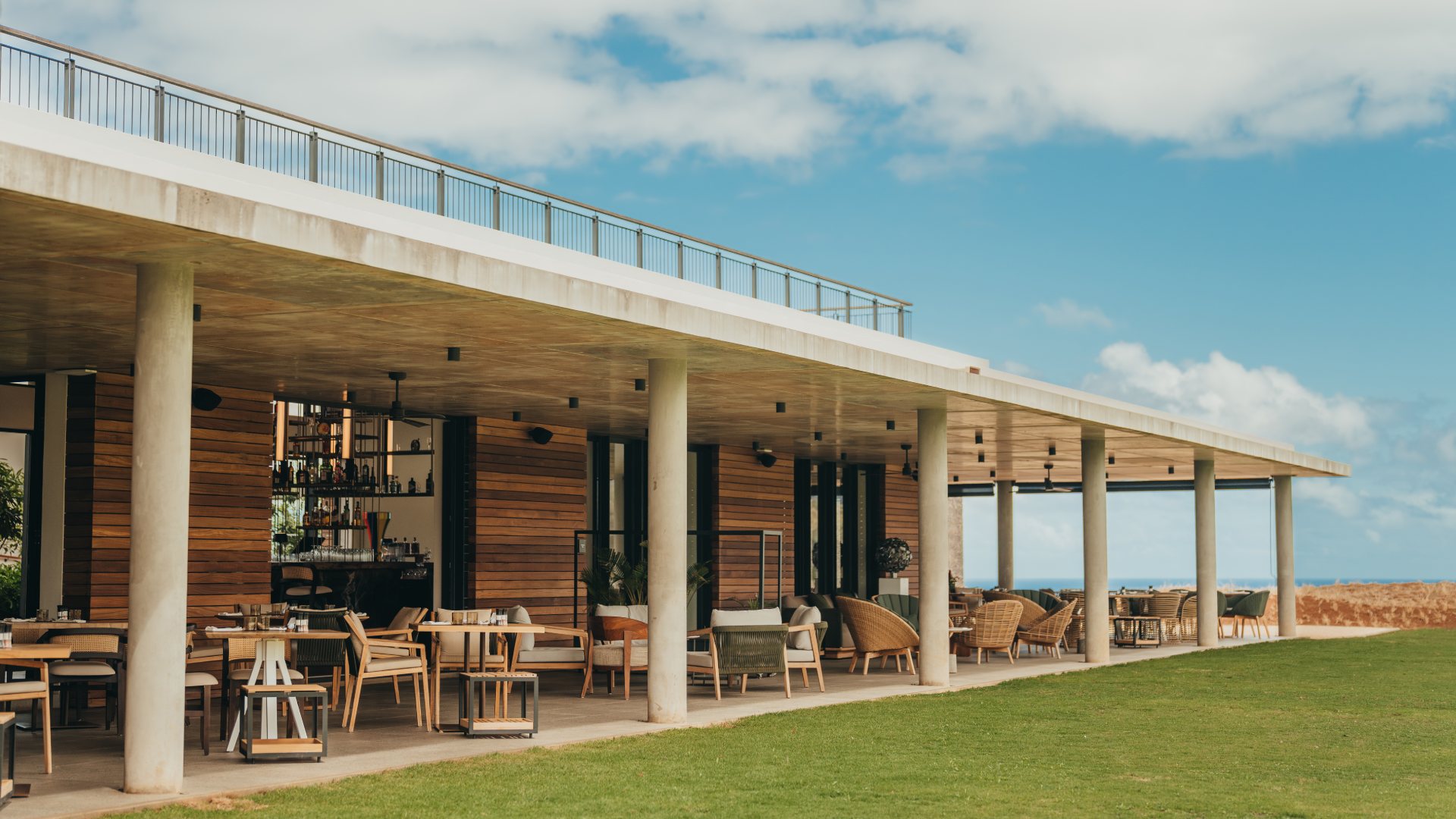 A lively beach club featuring colorful umbrellas, sunbathers, and a view of the ocean, creating a relaxing seaside atmosphere.